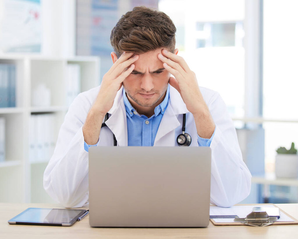Stress, anxiety or burnout for doctor with laptop working on medicine, medical or healthcare research. Headache, head pain or migraine for hospital employee, worker or career man with digital tech. - Valokuva, kuva
