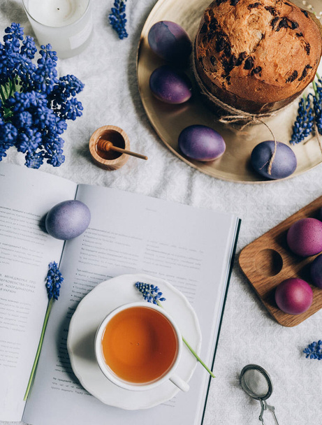 pohled shora na velikonoční složení vajec, šálek čaje, kniha, květiny, velikonoční dort    - Fotografie, Obrázek