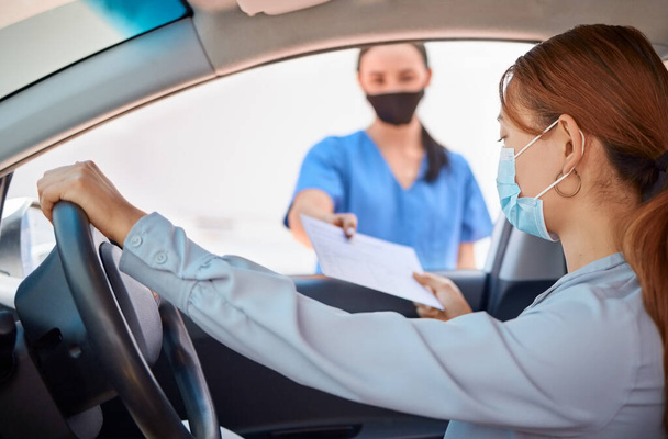 Covid test in car and drive thru, nurse giving patient forms to fill in. Woman in vehicle wearing a mask and taking documents from medical worker. Masks, coronavirus and testing on remote site. - Foto, Imagen