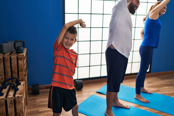 Familie lächelt zuversichtlich beim Stretching im Sportzentrum - Foto, Bild