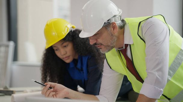 Professional construction engineers team using blueprint of project plan brainstorming and working together at construction building, Architecture and building construction concept - Photo, Image