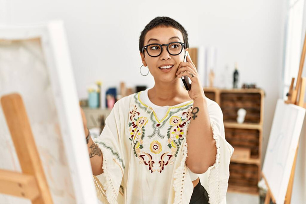 Młoda Latynoska kobieta rozmawia na rysunku smartfona w studio sztuki - Zdjęcie, obraz