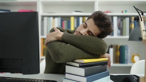 Joven estudiante hispano durmiendo con la cabeza en libros en la universidad de la biblioteca - Foto, imagen