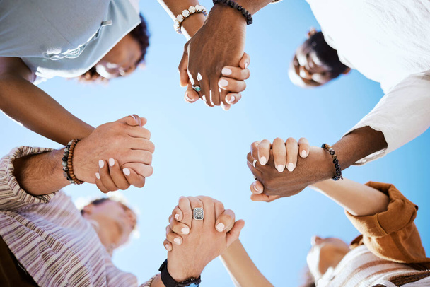 Diversity, support and people holding hands in trust and unity for community against sky background. Hand of diverse group in solidarity for united team building collaboration and teamwork success. - Foto, Bild