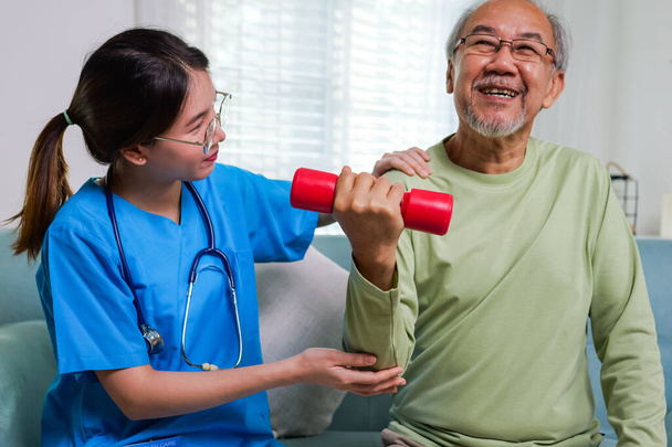 Senior people doing physical therapy after surgery operation, Elderly adult exercising by lifting weights at home, Senior patient at living room, Medical treatment concept - Foto, imagen