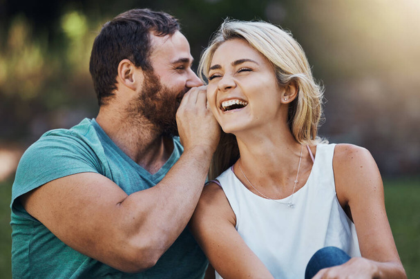 Gossip, história secreta e engraçada com o casal em um encontro romântico na natureza na Austrália no verão. Homem falando em um sussurro no ouvido de uma jovem mulher rindo enquanto feliz em um jardim juntos. - Foto, Imagem