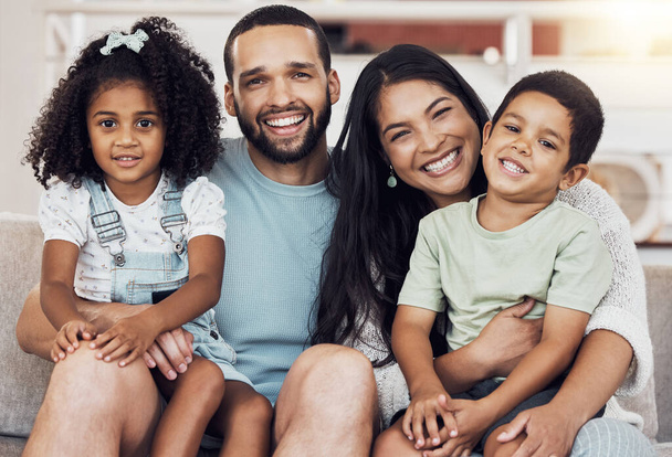 Happy, smile and portrait of a family bonding and relaxing together at home in puerto rico. Happiness, love and parents resting and holding their children with care at their comfortable house - Фото, изображение