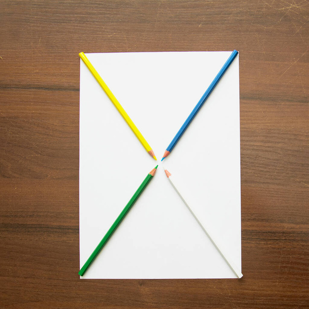 Egy ceruza fekszik egy üres papírlapon, gyönyörű háttérrel egy fotóstúdióban. - Fotó, kép