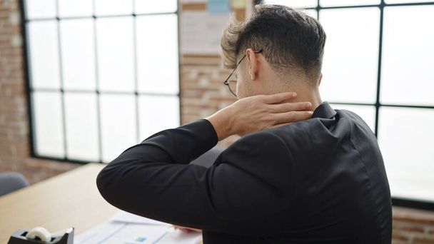 オフィスで働く首の痛みに苦しんでいる若いアラブ人の男のビジネスワーカー - 写真・画像