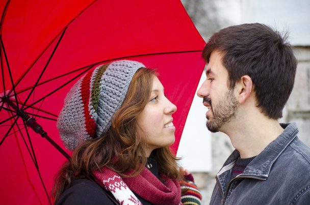 Ragazza caucasica e ragazzo innamorato sotto un ombrello rosso
 - Foto, immagini