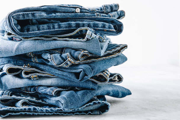 Jeans. Blue Jeans Hosen stapeln sich auf hellem Steinhintergrund, Kopierraum. - Foto, Bild