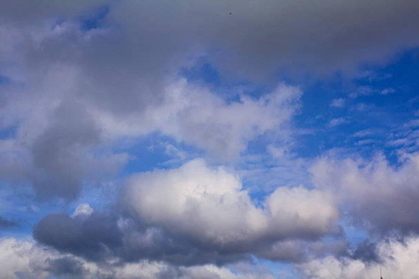 Onderaanzicht van wolken, grote witte en grijze pluizige wolken van onderen. Voor achtergrond, behang, digitaal kunstwerk gebruik en etc.. - Foto, afbeelding