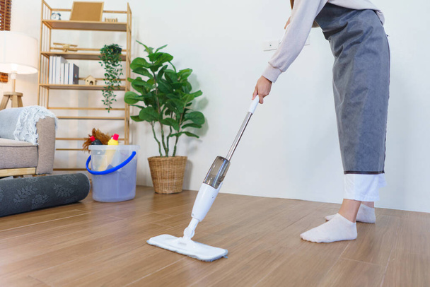 Housekeeping concept, Housemaid use mop to mopping and cleaning dust on the floor in living room. - Foto, imagen