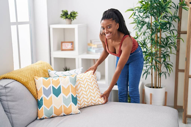 Afrykańska amerykanka uśmiechnięta pewna siebie organizuje sofę w domu - Zdjęcie, obraz