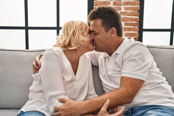 Middle age man and woman kissing and hugging each other at home - Foto, Bild