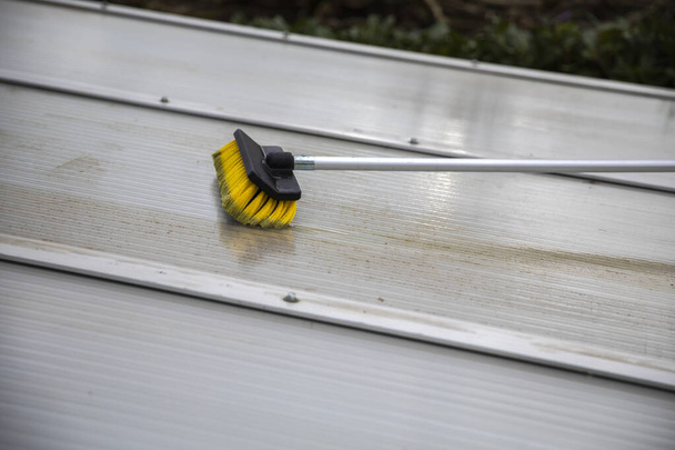 Lavando a cobertura do telhado pátio pérgola feita de alumínio. remover as algas sujas com sabão escova e água fechar no jardim de uma casa de limpeza terraço, trabalhadores, conceito - Foto, Imagem