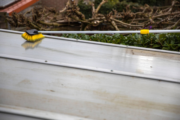 Pesu patio pergola katto kansi alumiinista. poistamalla likainen levät harjasaippualla ja vedellä lähellä puutarhassa talon terassi puhdistus, työntekijät, käsite - Valokuva, kuva