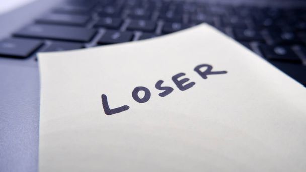 Loser written on note pad pasted on laptop related corporate life. - Photo, Image