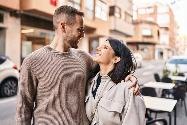 Muž a žena pár usměvavý sebevědomý objímání navzájem stojící na ulici - Fotografie, Obrázek