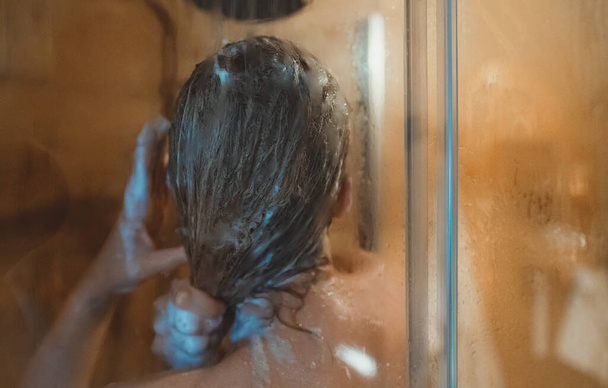 Woman washing her head in the shower. - Zdjęcie, obraz