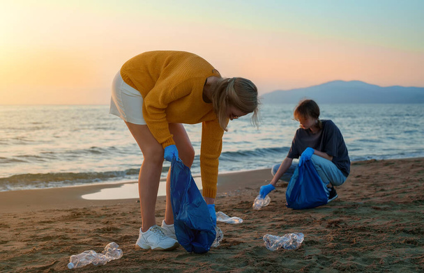Madre con hija salvando el planeta de la basura. - Foto, imagen