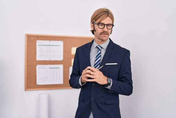 Young blond man business worker writing on cork board at office - Foto, Imagem
