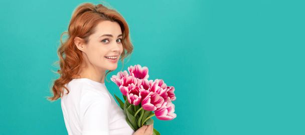 Frau isoliert Gesicht Porträt, Banner mit Attrappe Kopierraum. glückliches Mädchen mit Tulpenblumenstrauß auf blauem Hintergrund. Muttertag - Foto, Bild