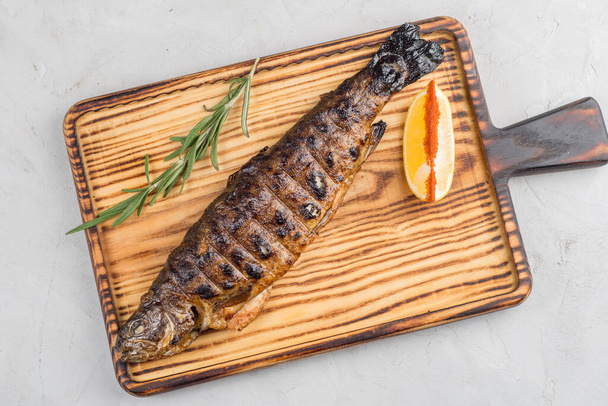 Grilling mackerel on a cutting board on a light background - Fotó, kép