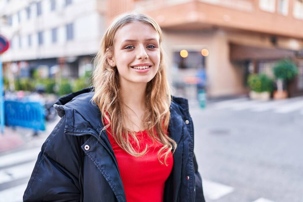 Sokakta kendine güvenen genç sarışın kadın gülümsüyor - Fotoğraf, Görsel