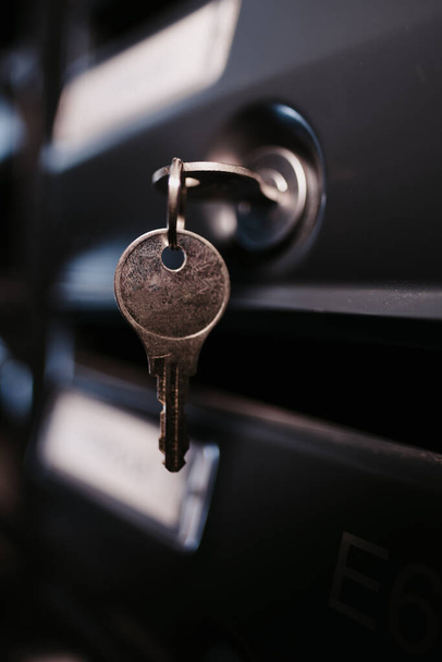 A close-up image of a key hanging on black mailboxes with a blurry backgr. Perfect for real estate investment, rental property, house buying, parcel pick up, delivery - Photo, Image