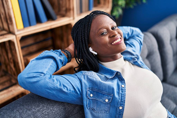 Afrikai amerikai nő zenét hallgat lazán a kanapén otthon - Fotó, kép