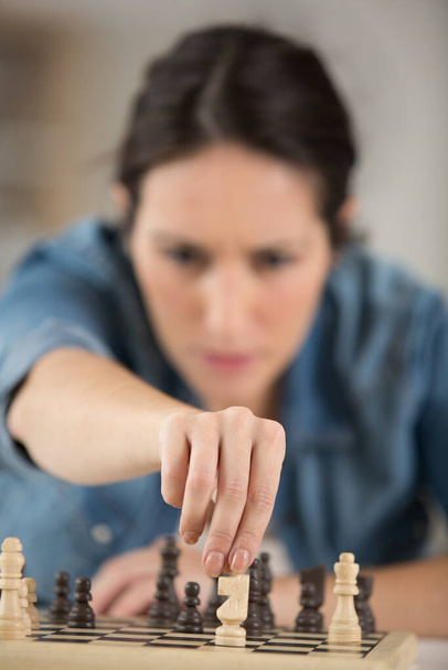 woman at home playing chess alone - 写真・画像
