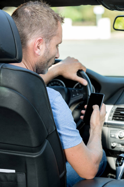 man talking on phone while driving car - Photo, image