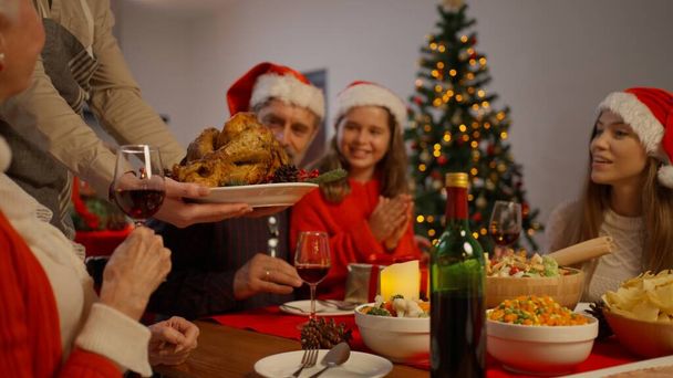 Christmas dinner party with roasted turkey, Big family celebrating Christmas together eating special food in the dinning room at home, Family with Christmas celebration concept - Fotó, kép