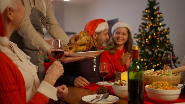 ロースト七面鳥とクリスマスディナーパーティー,クリスマスを祝うビッグファミリー一緒に自宅のダイニングルームで特別な食べ物を食べる,クリスマスのお祝いのコンセプトを持つ家族 - 写真・画像