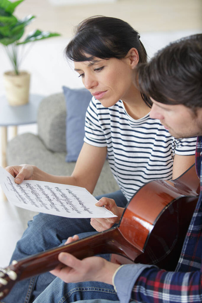 handsome man playing guitar for his girlfriend - 写真・画像