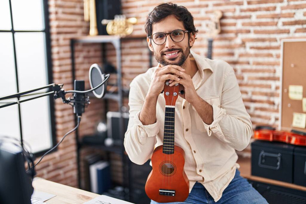 Jeune musicien hispanique tenant ukulele au studio de musique - Photo, image