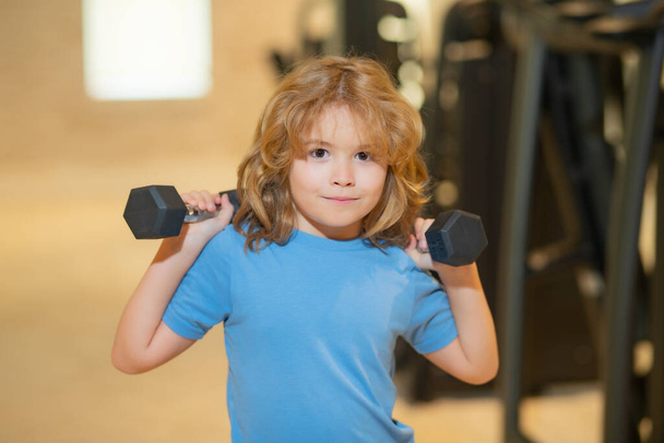 Kid boy working out with dumbbells. Sport and kids training - Foto, imagen