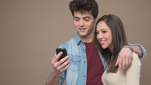 Smiling couple with mobile phone - Φωτογραφία, εικόνα