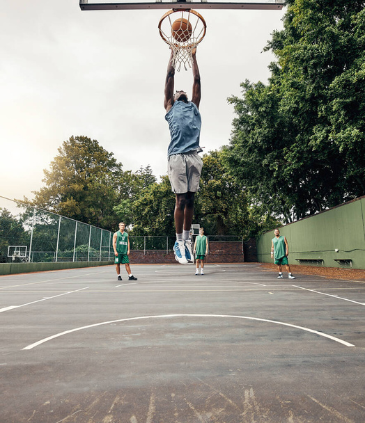 Basketball, player and winner on court jump, makes basket and score, celebration and victory playing against team. Competition, game day and dunk ball in net excited, practice and winning the game - Foto, Imagen