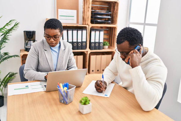 Férfi és női üzleti dolgozók, akik laptopot használnak és az okostelefonon beszélnek az irodában - Fotó, kép