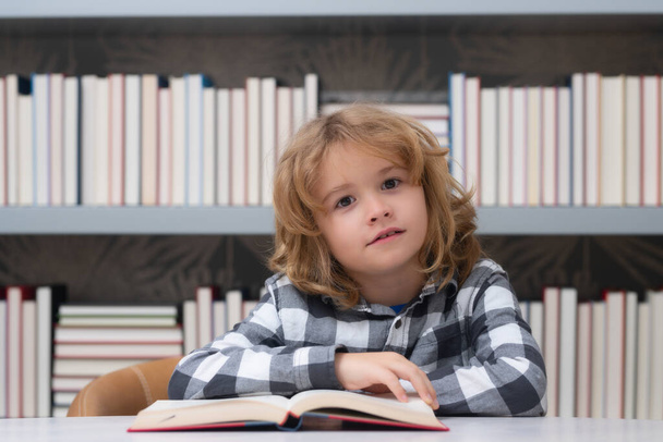 Bildung und Schulkonzept. Kind liest ein Buch in einer Schulbibliothek. Bildungskonzept für Jungen - Foto, Bild