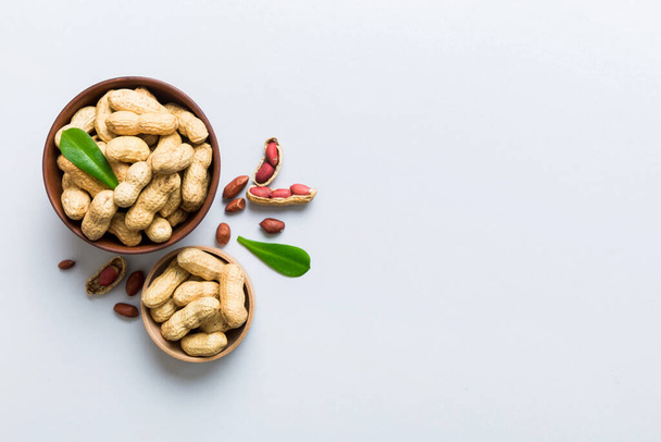 Fresh healthy peanuts in bowl on colored table background. Top view Healthy eating bertholletia concept. Super foods. - Foto, immagini
