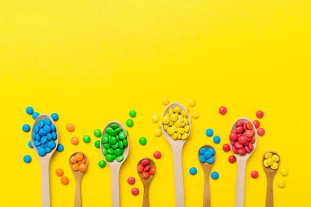 delicious colorful sweet candies on spoon on colored background . Confectionery decor top view with copy space. - Foto, immagini