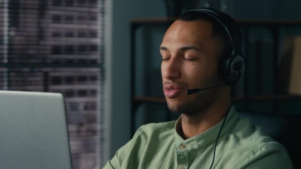 African american man manager call center worker communicate with client using headset young businessman salesman advisor in headphones consulting customer remote talk on video link on laptop in office - Filmagem, Vídeo