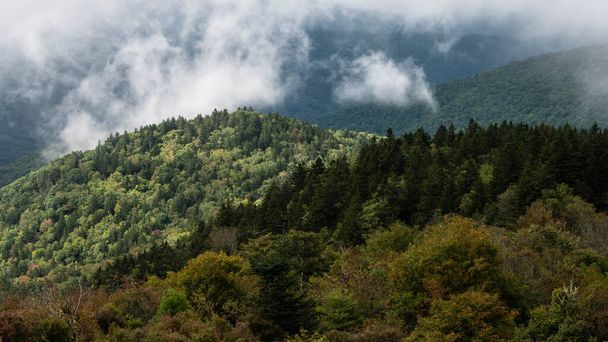 Sunlight Piercing the Clouds to Rest on the Slopes of the Appalachian Mountains Viewed Along the Blue Ridge Parkway - 写真・画像