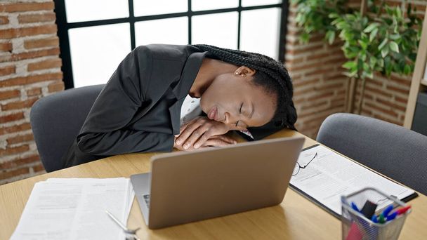 Afrikaans amerikaanse vrouw zakenman slapen op tafel op kantoor - Foto, afbeelding