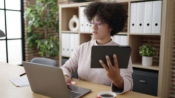 Jovem afro-americana mulher empresária usando touchpad e laptop no escritório - Foto, Imagem
