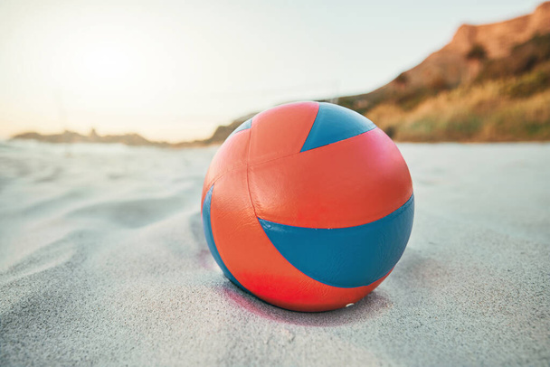 Пляж, м'яч і волейбол на піску, гра на заході сонця в пункті призначення тропічного океану. Фітнес, веселощі та літні види спорту на морі ввечері. Біле піщане узбережжя, волейбольний м'яч і порожній морський пейзаж
 - Фото, зображення