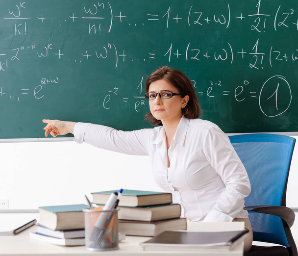 Η δασκάλα μαθηματικών μπροστά από τον πίνακα. - Φωτογραφία, εικόνα